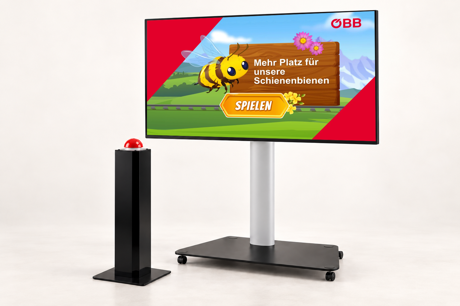 GAMIFY Ausweichspiel Setup: Bildschirm auf fahrbarem Standfuß mit dem ÖBB Schienenbienen-Spiel und daneben eine Buzzer-Stele mit rotem Buzzer, mit dem gespielt wird